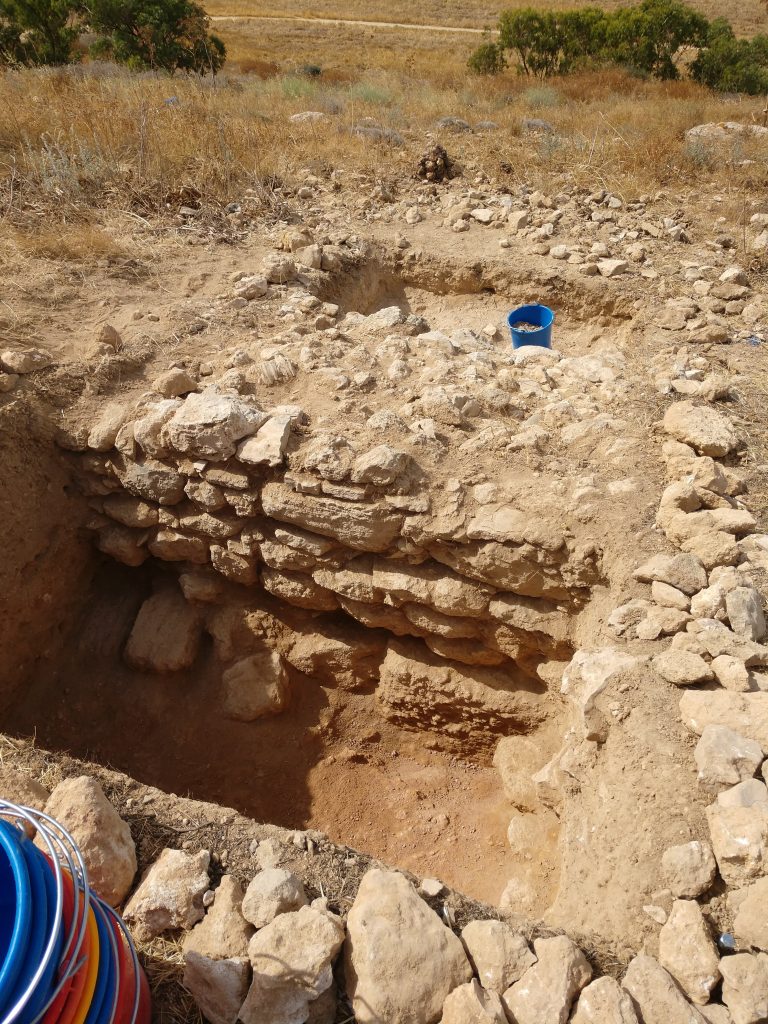 A large irregular stone wall in a trench