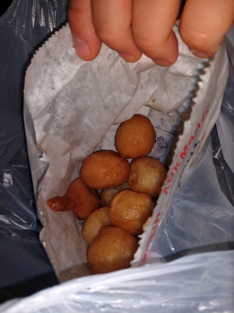 A bag with several golf-ball sized pieces of fried dough